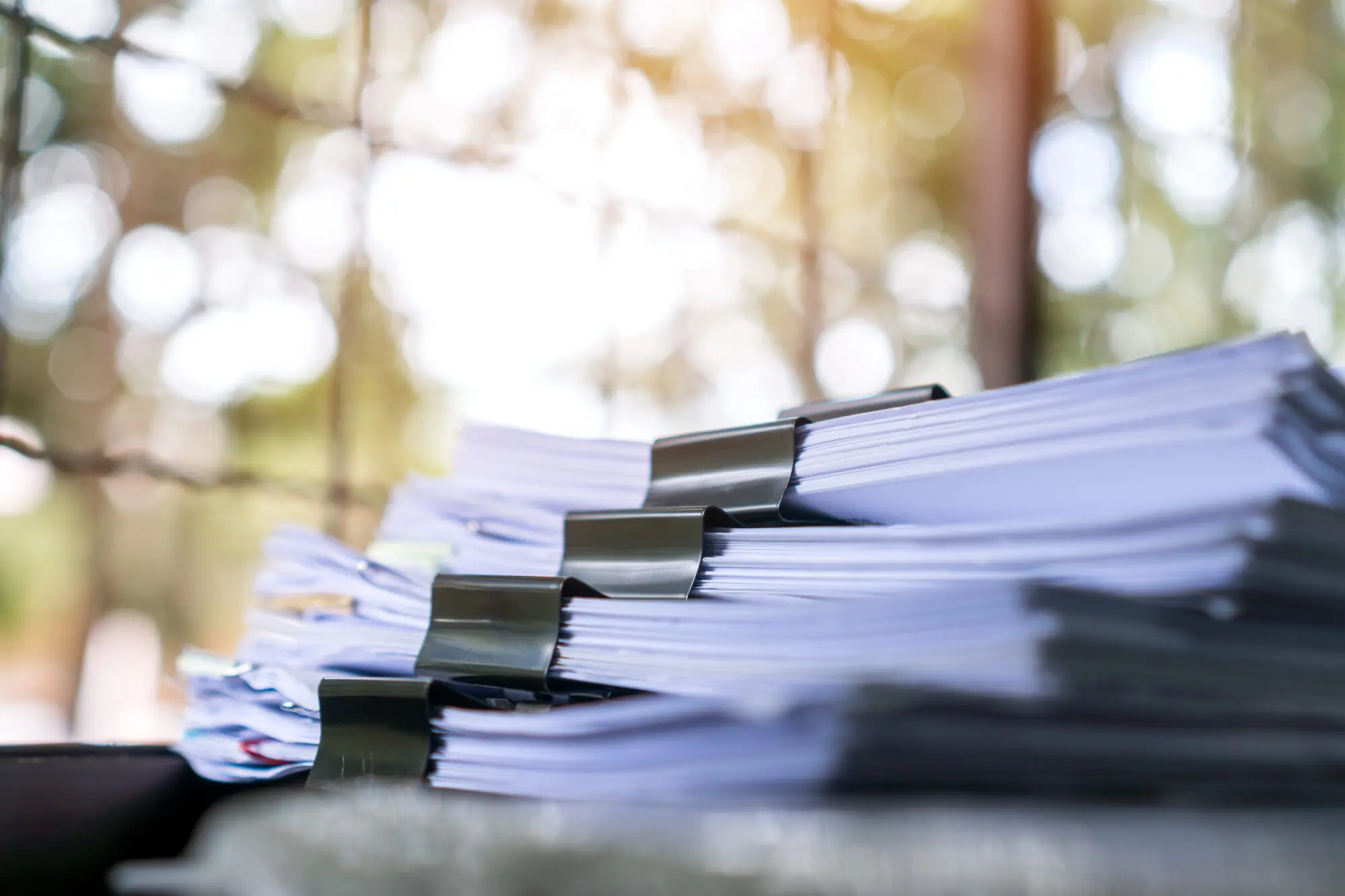 Stacks of clipped documents and records on a desk